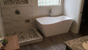 Hardwood Floor Bathroom with Marble Tile and Modern Bathtub